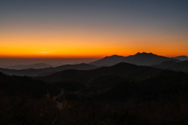 Otlar ve akşamları dağlı günbatımı.