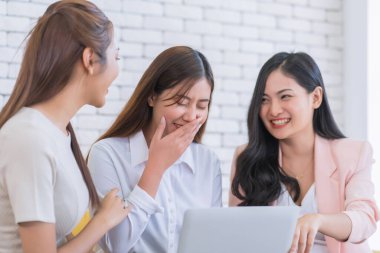 Güzel genç iş kadınları oturma odasında dizüstü bilgisayarlarıyla web sitesine bakıyorlar. Mutlu arkadaşlık ilişkisi konsepti.