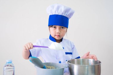 Elbiseli ve aşçı şapkalı güzel kızlar. Mutfak pastası pişiriyorum. Çocuklar evde kurabiye yapar, çocuklar yumurtalı tatlı yapar..