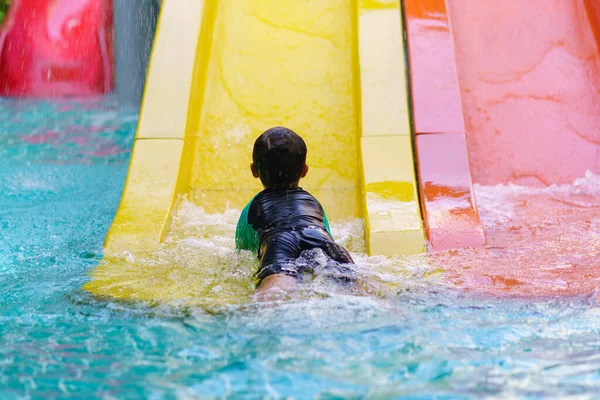 暖かい夏の日の間にウォーターパークライドを滑り降りる幸せな少年や子供 — ストック写真