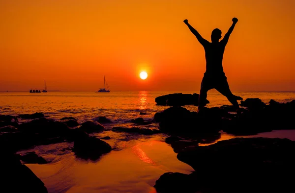 Salto feliz durante o pôr do sol na praia — Fotografia de Stock