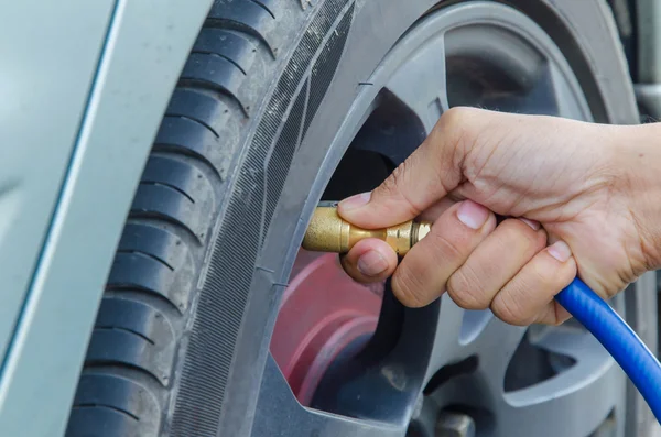 Llenado de aire en un neumático de coche — Foto de Stock