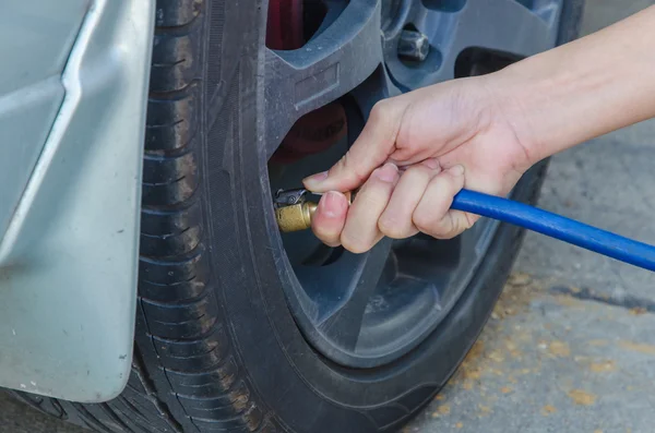 Filling air into a car tire — Stock Photo, Image