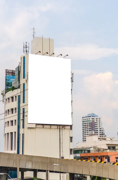 Grande cartellone bianco su strada con sfondo vista città — Foto Stock