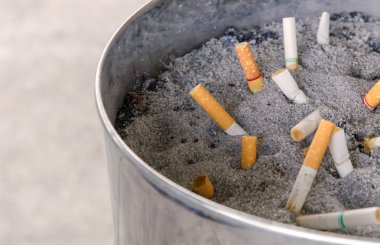 Kum ile kirli kül tablası içinde sigara füme