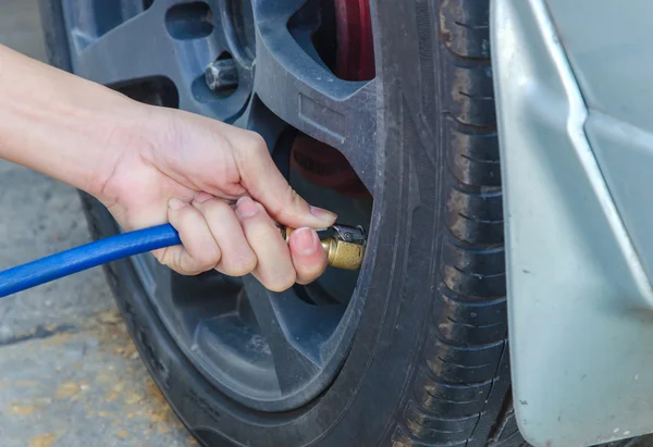 Filling air into a car tire — Stock Photo, Image