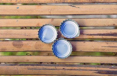 Üç şişe kapağı üzerinde bambu