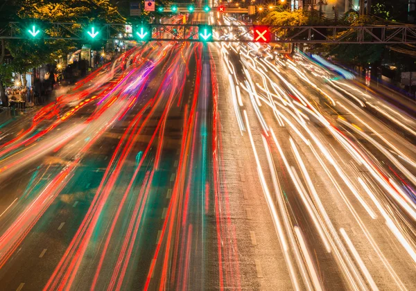 Fluxos de luz provenientes do tráfego em curso na estrada distrital de negócios — Fotografia de Stock