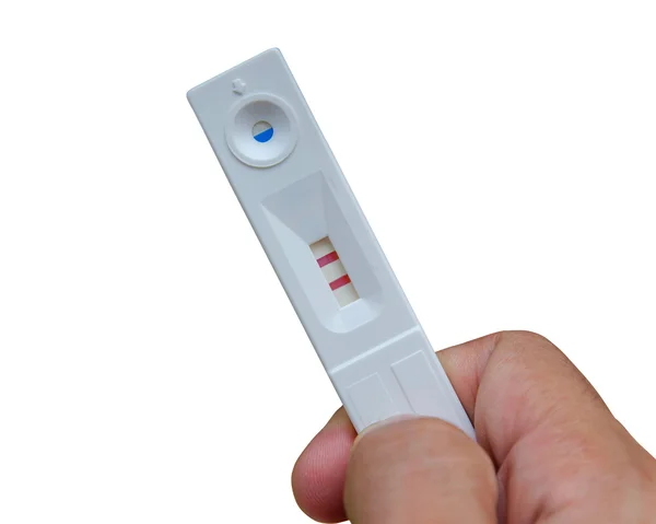 Проведение положительного теста на беременность с двумя красными полосками — стоковое фото