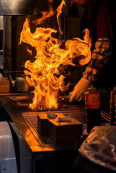 Chef grilling bbq with flame of burning in restaurant — Stock Photo, Image