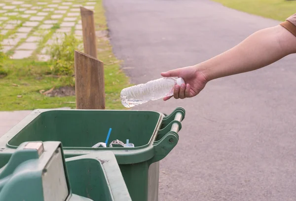 Hand gooien fles in vuilnisbakken — Stockfoto