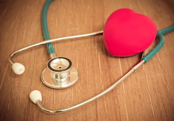 Red heart and stethoscope on wooden background. — Stock Photo, Image