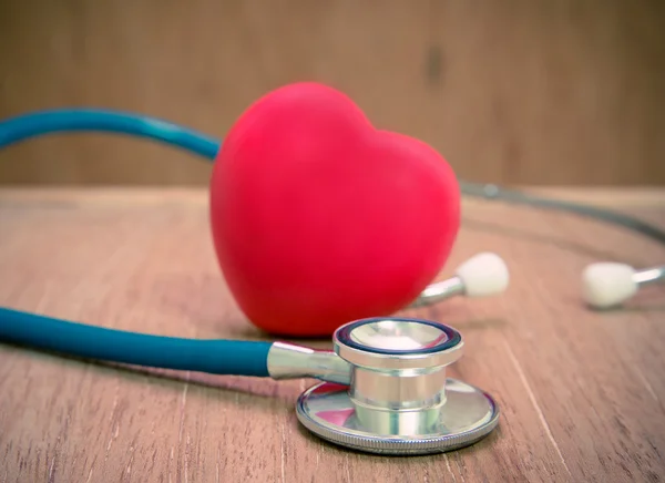 Красное сердце и стетоскоп на деревянном фоне . — стоковое фото
