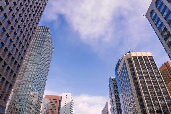 Rascacielos contra cielo y edificio en ciudad —  Fotos de Stock