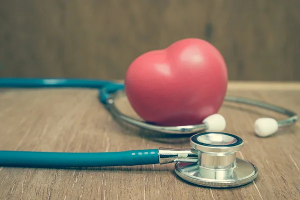 Red heart and stethoscope on wooden background. — Stock Photo, Image