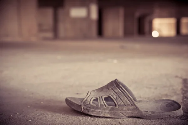 Chinelos velhos ou sapato em um edifício abandonado — Fotografia de Stock