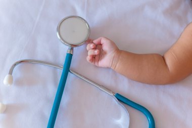 Yeni doğan bebek kız elinde stetoskop tıp aletleri