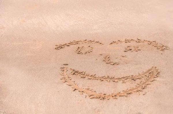 Cara de escritura en la arena en la playa — Foto de Stock