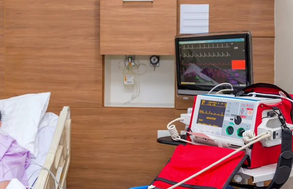 Desfibrilador na sala de UTI do hospital com equipamentos médicos — Fotografia de Stock