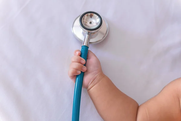 Medische instrumenten stethoscoop in hand van pasgeboren babymeisje — Stockfoto