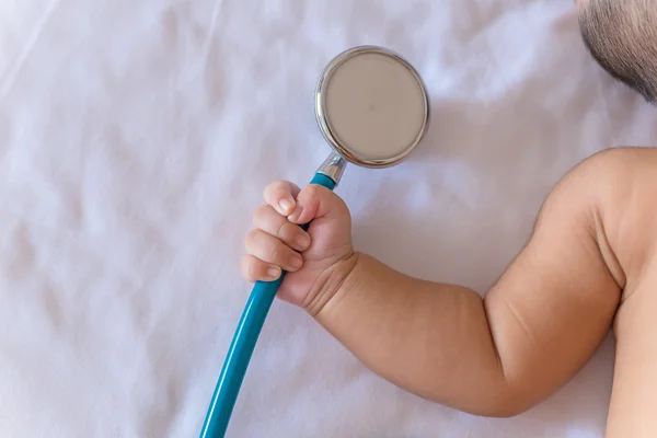 Instrumentos médicos estetoscópio na mão de bebê recém-nascido menina — Fotografia de Stock