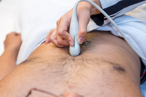 Zbliżenie człowieka wykonującego USG brzucha przez lekarza — Zdjęcie stockowe