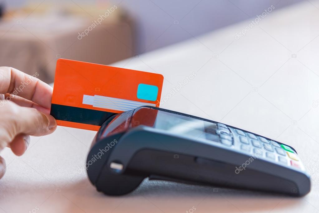 Hand Swiping Credit Card on POS terminal in Store