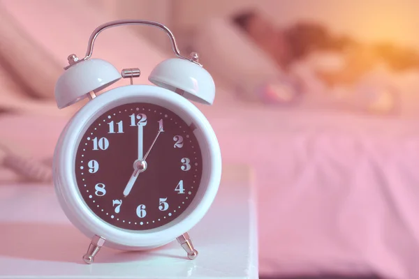 Alarm clock on the bed in bedroom — Stock Photo, Image