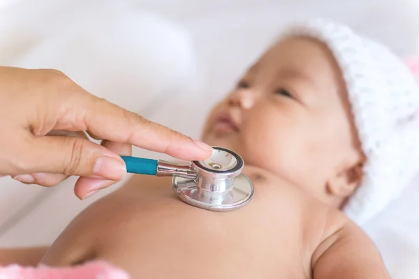 Yeni doğan bebek kız elinde stetoskop tıp aletleri — Stok fotoğraf