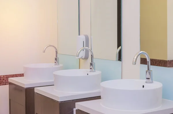 Белые раковины в интерьере ванной комнаты с гранитной плиткой — стоковое фото