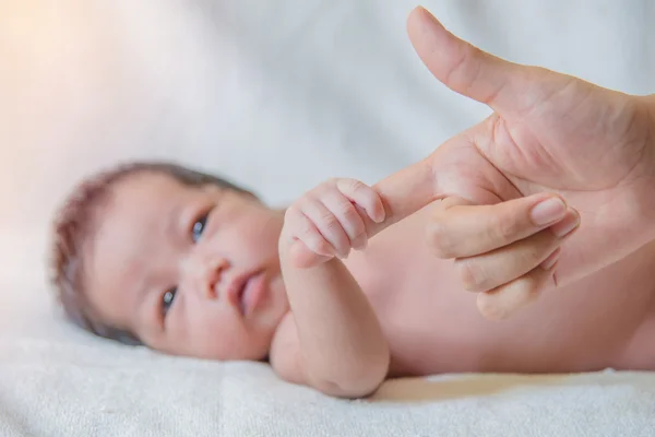 Cute newborn baby hand holding mother's finger — Stock Photo, Image
