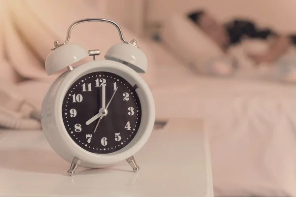 Alarm clock on the bed in bedroom, retro style — Stock Photo, Image