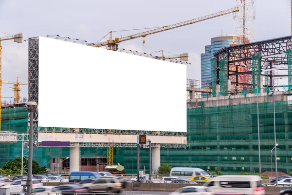 Blank billboard ready for new advertisement on road with Constru — Stock Photo, Image