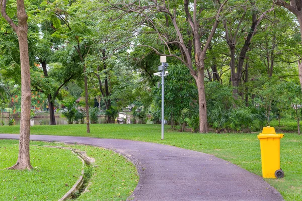 Мусорные баки в парке рядом с дорожкой — стоковое фото