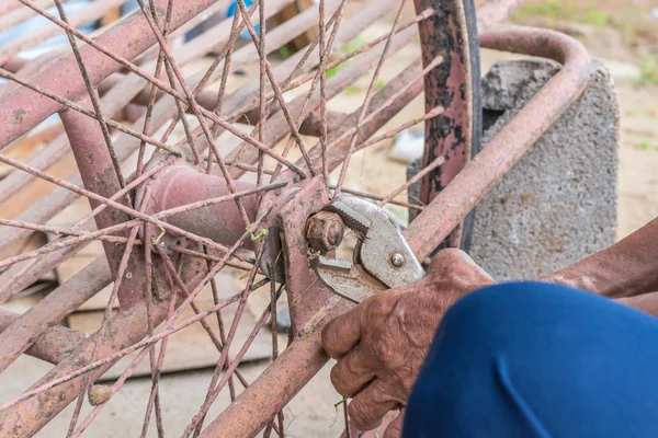 Primer plano de la persona manos reparaciones rueda bicicleta con alicates — Foto de Stock