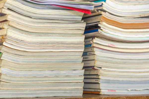 Many books pile on wooden table at library — Stock Photo, Image