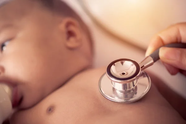 Pediatric doctor exams newborn baby girl with stethoscope in hos — Stock Photo, Image