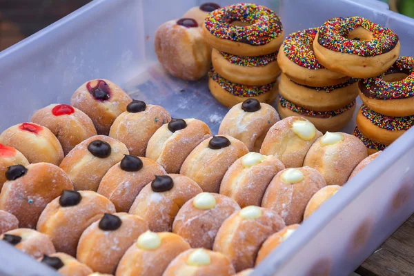 Varios donuts acristalados en caja en el mercado — Foto de Stock