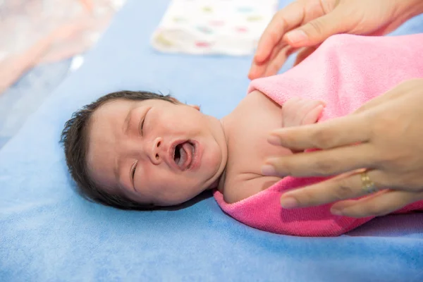 Новорожденная девочка плачет на кровати — стоковое фото
