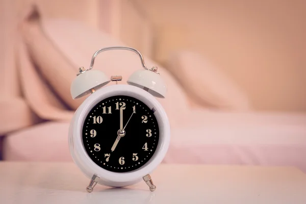 Despertador na cama no quarto, estilo retro — Fotografia de Stock