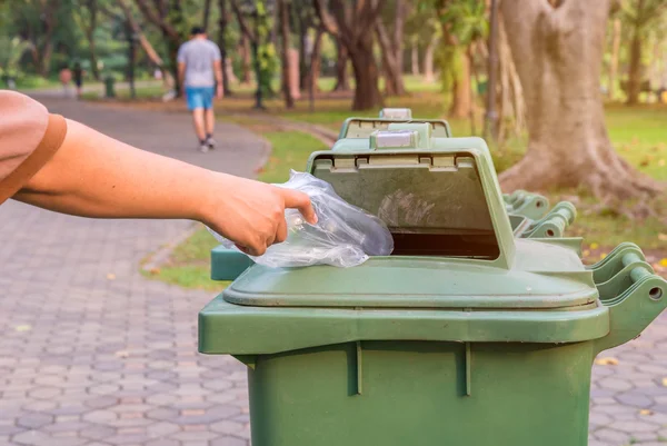 Hand gooien fles in vuilnisbakken — Stockfoto