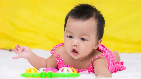 Retrato de bebê bonito sorridente menina na cama com brinquedo — Fotografia de Stock