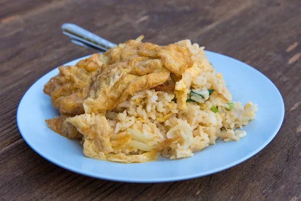 Pork fried rice with omelet on wood table — Stock Photo, Image