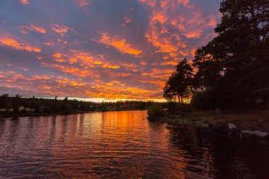 Norveç 'te güneş battıktan sonra Mjosa Gölü' nde doğal kızıl gökyüzü.