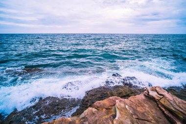 Pürüzsüz Dalga ve Kaya manzaralı bir deniz. Tatil seyahatinde deniz manzarası dinlenme zamanı..