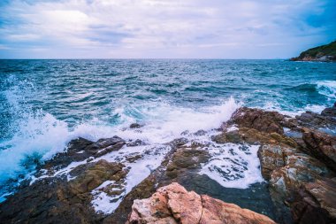 Pürüzsüz Dalgalı Deniz Okyanusu ve mavi gökyüzü ile Kaya Manzarası. Deniz manzaralı tatil zamanı..