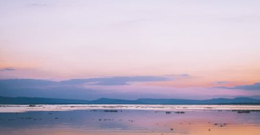 Panorama Gölü ve dağ manzarası Pembe gökyüzü ile gün batımında