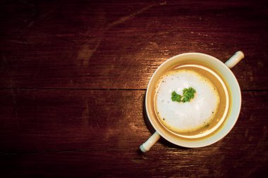 Seramik kasede mantar çorbası. Tahta masada sağlıklı bir kahvaltı..