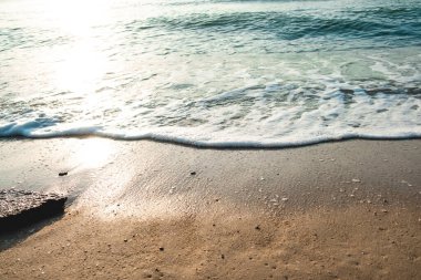 Dalga Dalgası Kum Sahil Köpüğü 'nü kapatın. Kumsalda köpüklü deniz dalgasına yakın çekim. Tatil Yaz arkaplanı