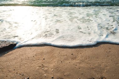 Dalga Dalgası Kum Sahil Köpüğü 'nü kapatın. Kumsalda köpüklü deniz dalgasına yakın çekim. Tatil Yaz arkaplanı